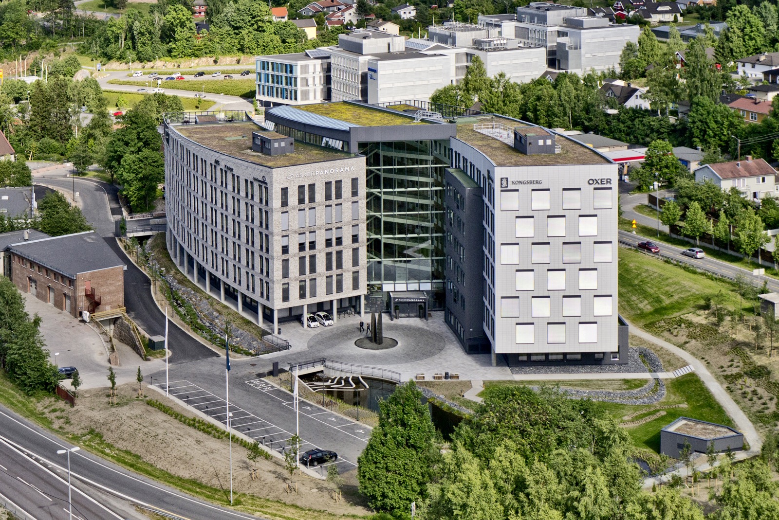Illustrasjon av fasaden og utomhus, sett fra E18, i en tidligere prosjekteringsfase.